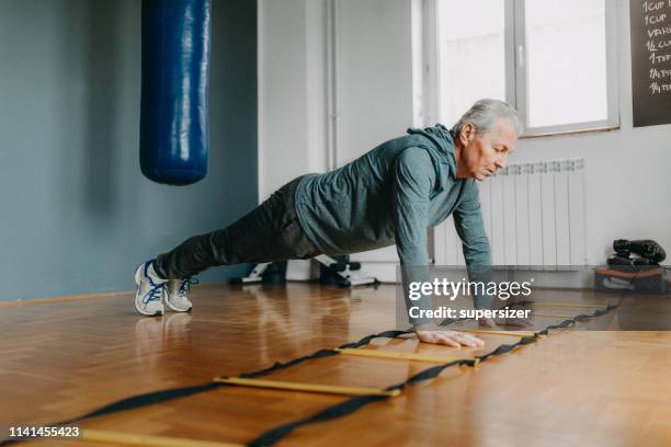 senior man exercising with the assistance from young woman - personal trainer - aerobic stock pictures, royalty-free photos & images