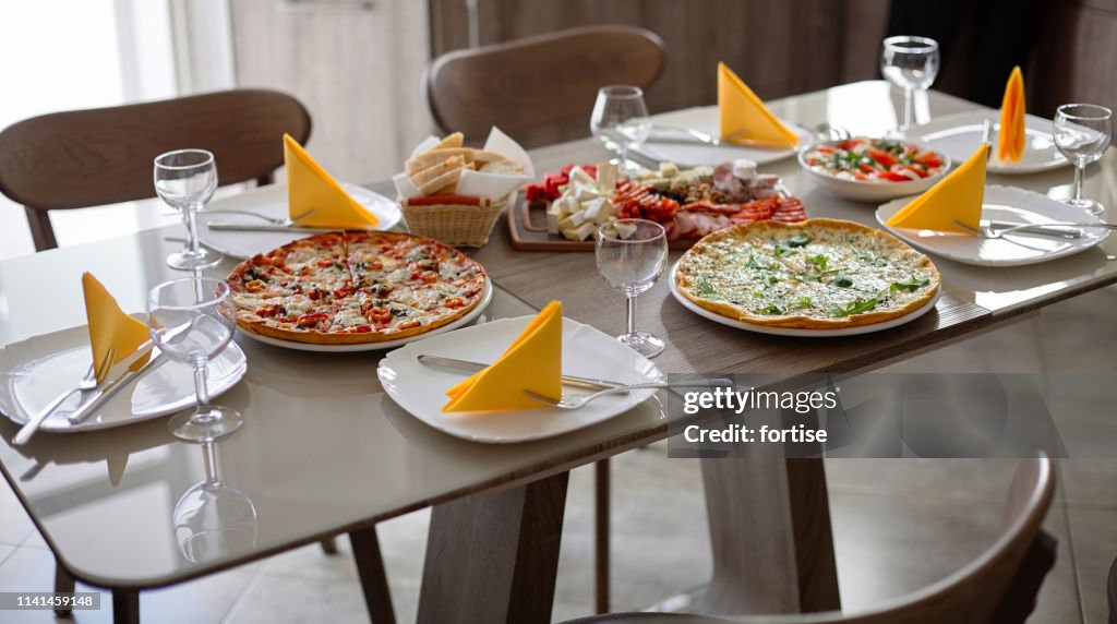 Dinner table served with silverware,glass stemware and delicious dishes