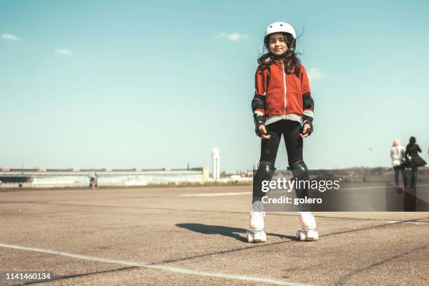 klein meisje op rolschaatsen op tempelhofer feld in berlijn - rolschaatsen schaats stockfoto's en -beelden