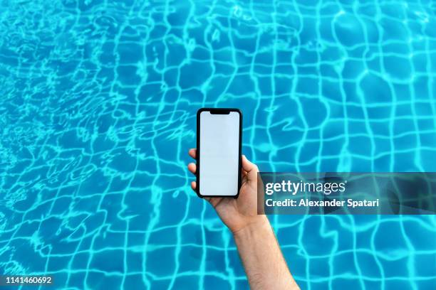 using smartphone in the swimming pool - swimming pool and hand stock-fotos und bilder