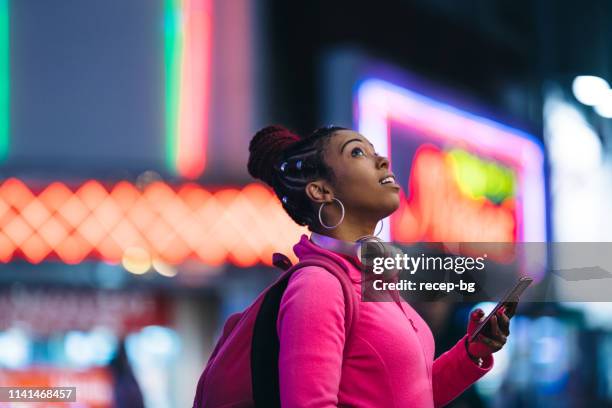 vrouw met behulp van slimme telefoon 's nachts - citylight stockfoto's en -beelden