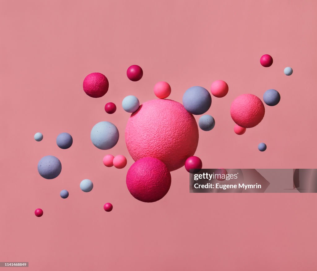 Abstract multi-colored spheres on pink background