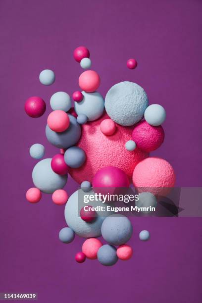 abstract multi-colored spheres on purple background - intensidad del color fotografías e imágenes de stock