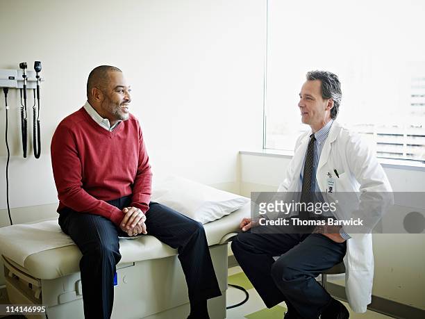 mature male patient in discussion with doctor - mannelijk stockfoto's en -beelden