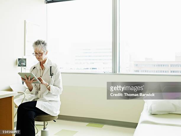 Female doctor using digital tablet in exam room