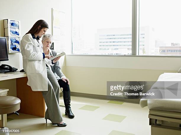 doctor and patient working on digital tablet - doctor and patient talking imagens e fotografias de stock