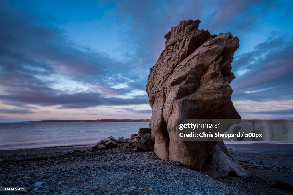 Seacoast with rock formation against dramatic sky
