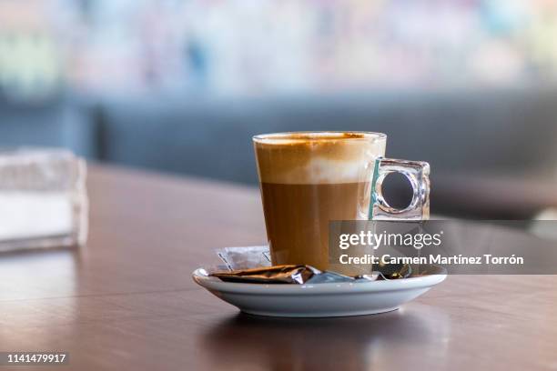 glass of coffee with beautiful latte art on the wooden table. - coffee table cafe stock-fotos und bilder