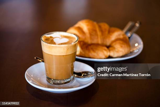 glass of coffee with beautiful latte art on the wooden table. - croissant café stock pictures, royalty-free photos & images