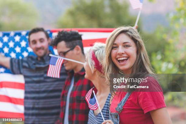 gruppo di amici millenari con una grande bandiera americana - political party foto e immagini stock