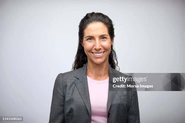 portrait of smiling well-dressed businesswoman - portrait studio sourire corporate photos et images de collection