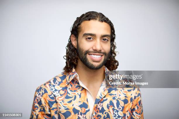 smiling bearded young man having long curly hair - long beard stockfoto's en -beelden