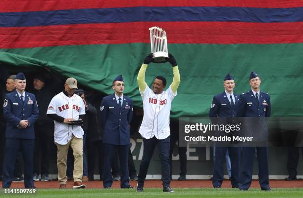 Former MLB player Pedro Martinez walks on the field with the 2018 World Series Championship trophy before the home opener at Fenway Park on April 09,...