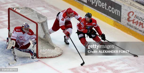 Denmark's goalkeeper Sebastian Dahm looks on as Denmark's Morten Poulsen and Austria's Michael Raffl vie for the puck during the international...