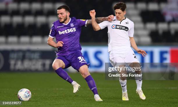 Swansea player Daniel James is challenged by Tom Edwards of Stoke during the Sky Bet Championship match between Swansea City and Stoke City at...