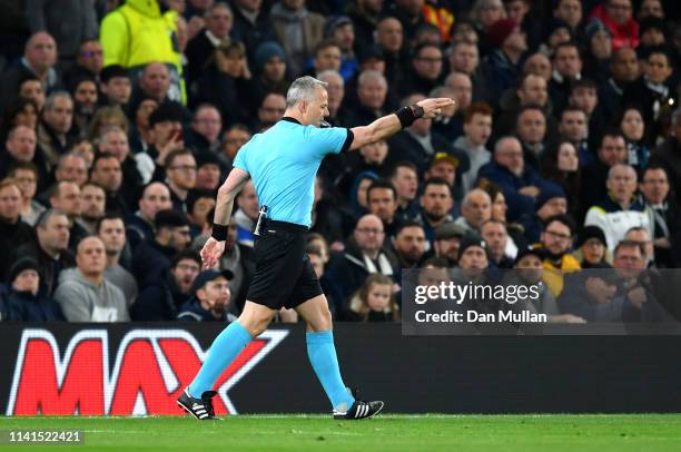 Referee Bjorn Kuipers points to the spot to award Manchester City a penalty after reviewing VAR during the UEFA Champions League Quarter Final first...