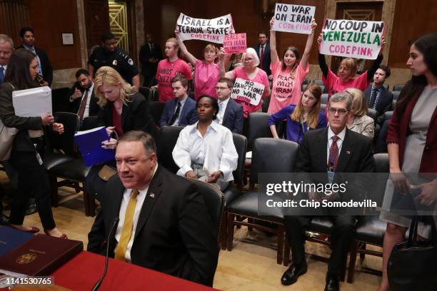 Protesters from Code Pink stand up as U.S. Secretary of State Mike Pompeo arrives to testify before the Senate Appropriations Committee's State,...