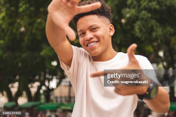 portrait of a brazilian guy doing frame with fingers looking at you - youth culture stock pictures, royalty-free photos & images