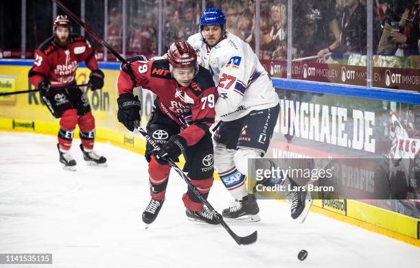 Colin Ugbekile of Koeln is challenged by Brendan Mikkelson of Mannheim during the fourth game of the DEL Play-Offs Semi Final between Koelner Haie...