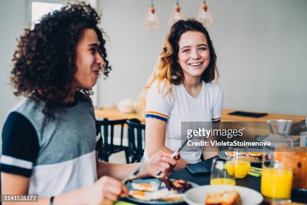 glückliche familie beim frühstück - bacon and eggs stock-fotos und bilder