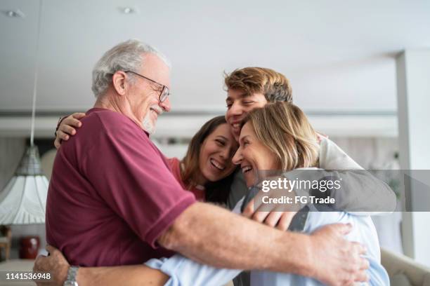 el nieto y los abuelos abrazan - reencuentro fotografías e imágenes de stock