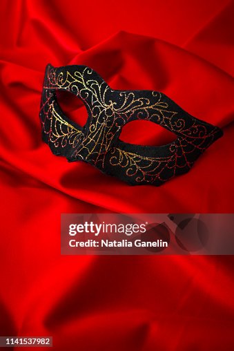 Black masquerade mask on red Black masquerade mask on red