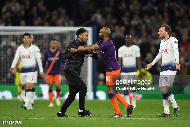 Fabian Delph of Manchester City confronts a pitch invader during the UEFA Champions League Quarter Final first leg match between Tottenham Hotspur...