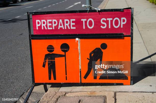 signs warning drivers to prepare to stop and heed the worker with a stop sign because of roadwork - traffic controller stop sign fotografías e imágenes de stock