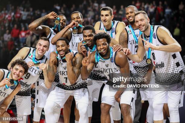 Bologna players pose for a photo with their medals on the podium after winning the final basketball match between Spanish team CB 1939 Canarias...