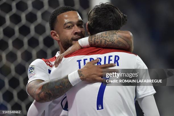 Lyon's French midfielder Martin Terrier is congratulated by Lyon's Dutch forward Memphis Depay after scoring a goal during the French L1 football...