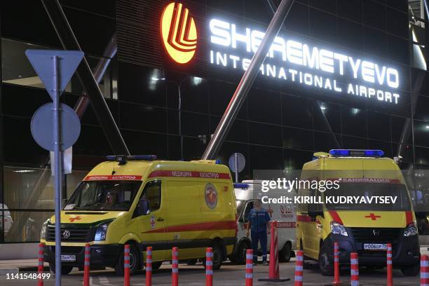 Ambulances are parked in front of the terminal building of the Sheremetyevo Airport outside Moscow after a Russian-made Superjet-100 on fire...