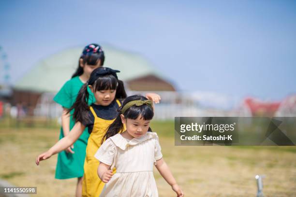 three little sisters walking in queue - toddler marching stock pictures, royalty-free photos & images