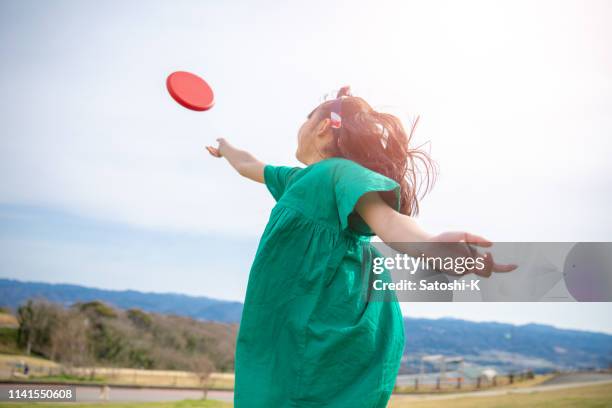 little girl throwing disc to the sky - throwing frisbee stock pictures, royalty-free photos & images