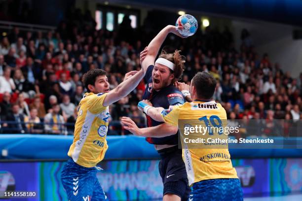 Mikkel Hansen of Paris Saint Germain is shooting the ball against Marko Mamic and Krzysztof Lijewski of PGE Vive Kielce during the Champions League...