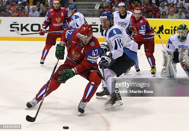 Ossi Vaananen of Finland and Alexander Radulov of Russia battle for the puck during the IIHF World Championship semi final match between Finland and...