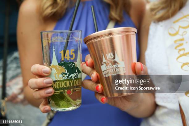 Women display mint julep drinks at the 145th running of the Kentucky Derby at Churchill Downs on May 4th, 2019 in Louisville, Kentucky.