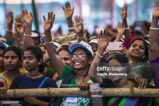 Supporters react while listening to West Benghal Chief Minister Mamata Banerjee, not pictured, during a campaign rally in Swarupnagar, West Bengal,...