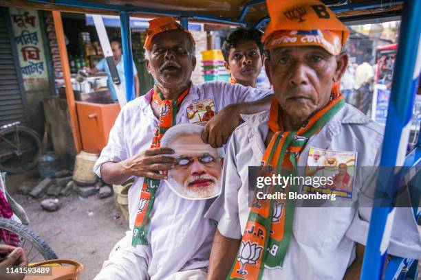 Bharatiya Janata Party supporters sit in an auto rickshaw during a campaign rally in Maslandapur, West Bengal, India, on Monday, April 29, 2019. West...