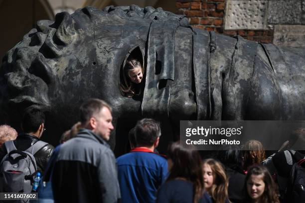 Tourists seen around one of Krakóws most well-known landmarks and a popular meeting place, Eros Bendato sculpture, the work of Polish artist Igor...