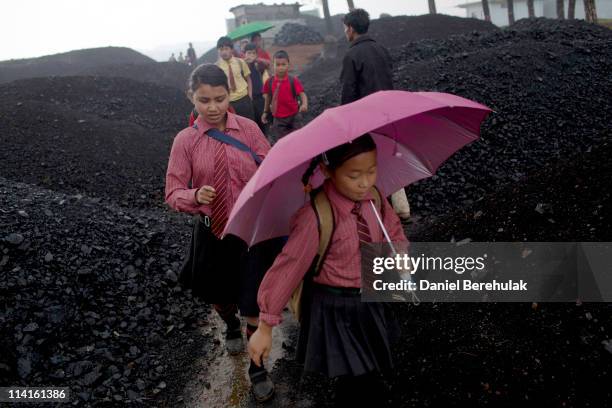 School children walk through a coal depot on their way home from school on April 14, 2011 in Lad Rymbai, in the district of Jaintia Hills, India....