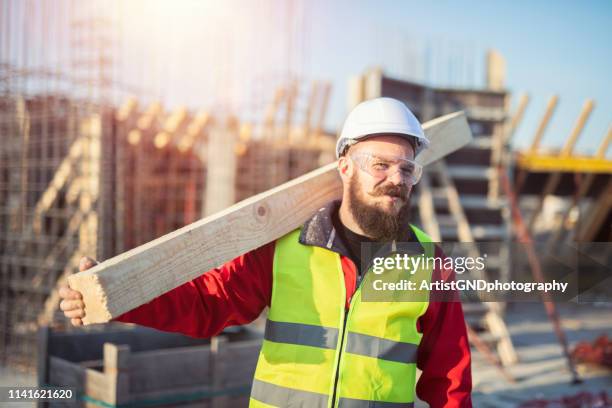 jonge bouw arbeider die houten raad draagt - carpentry stockfoto's en -beelden