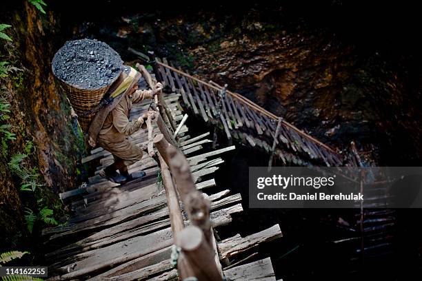 Year old Prabhat Sinha, from Assam, carries a load of coal weighing 60kg's, supported by a head-strap, as he ascends the staircase of a coal mine on...