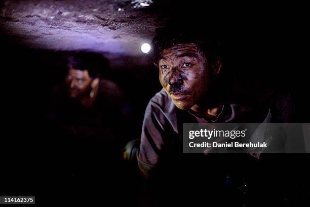 Year old Shyam Rai from Nepal makes his way through a rat hole tunnels inside of a coal mine 300 ft beneath the surface on April 13, 2011 near the...