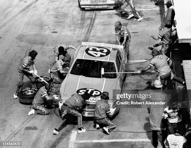 Richard Petty, driver of the STP Pontiac, makes a pit stop at the Daytona International Speedway during the running of the 1984 Firecracker 400 on...