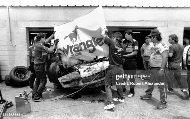 Crew members for NASCAR driver Dale Earnhardt Sr. Work on the driver's damaged car after an accident during the 1986 Daytona 500 on February 16, 1986...