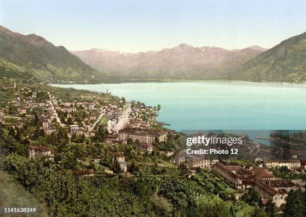 Early colour photograph of Locarno, Tessin, Switzerland. It shows a scenic shot looking over the town, showing the mountains and river in the...