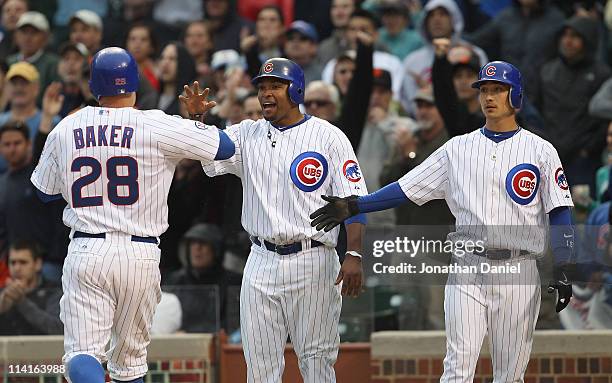 Marlon Byrd and Darwin Barney of the Chicago Cubs greet teammate Jeff Baker after scoring runs in the 7th inning against the San Francisco Giants at...