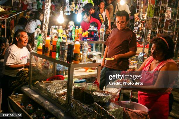 the atmosphere of a typical mexican food and taco stand in the historic center of oaxaca in southern mexico - mexican street market stock pictures, royalty-free photos & images