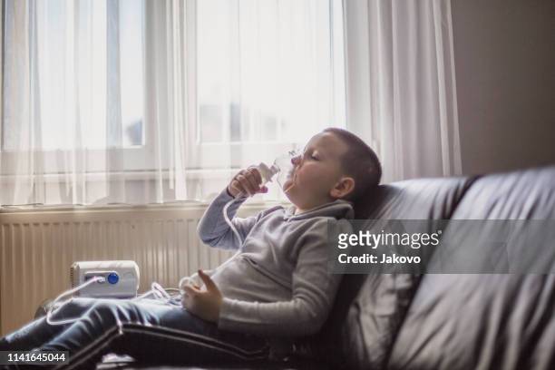 child using inhaler at home - respiratory disease stock pictures, royalty-free photos & images