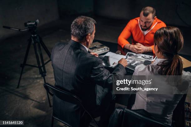 police investigating a prisoner - prison jumpsuit stock pictures, royalty-free photos & images